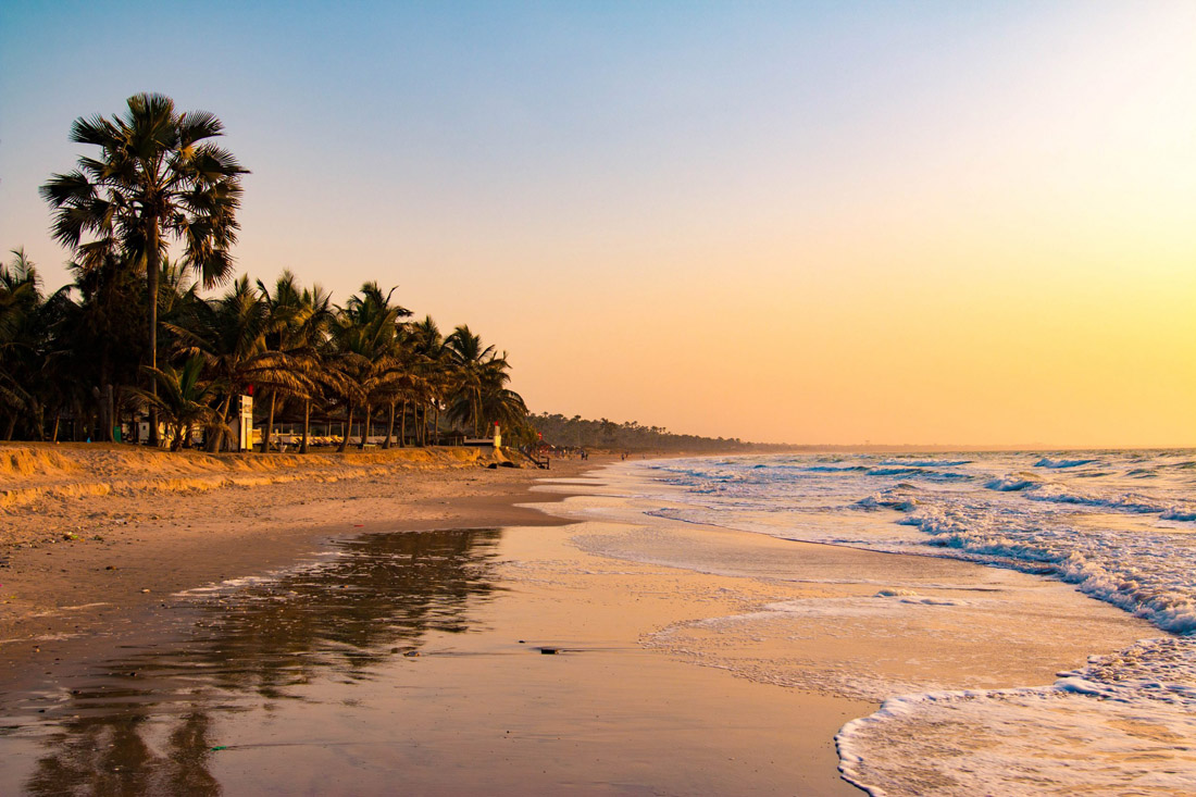 Sweeping sandy beach under clear skies in Serrekunda, Gambia